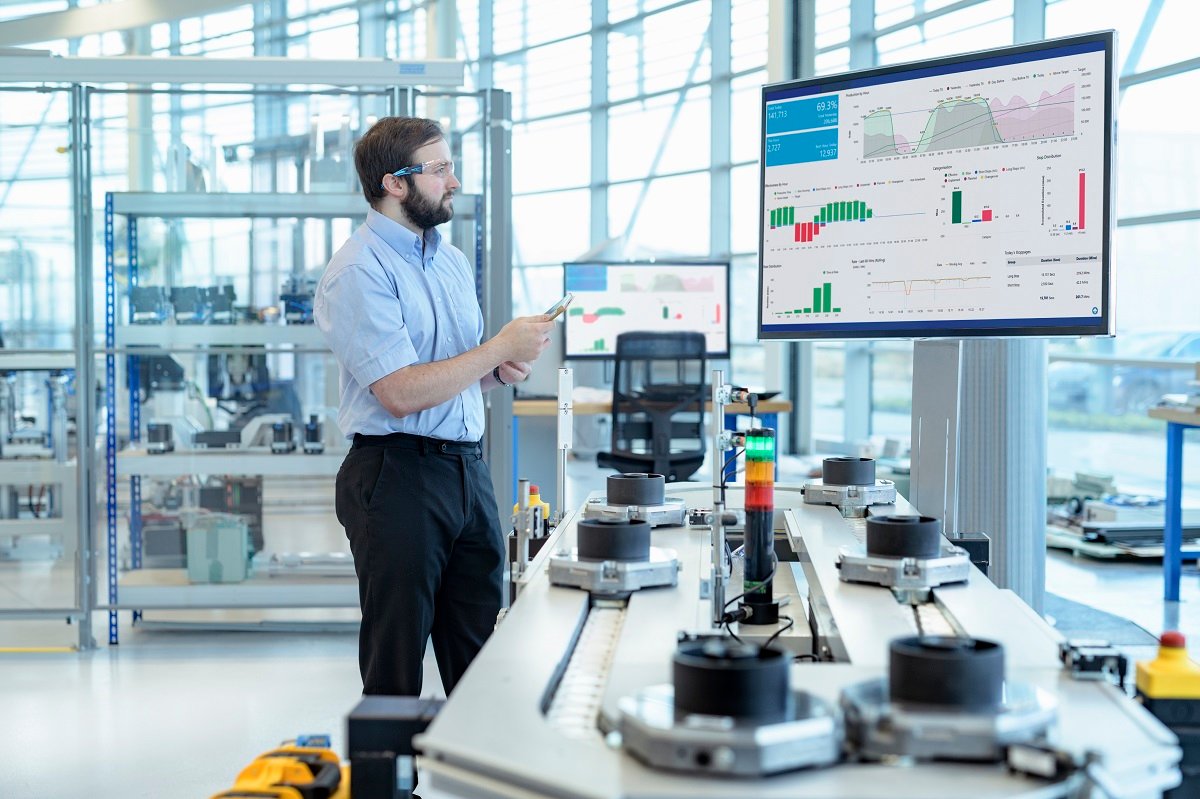 Engineer testing a robotic production simulator in robotics research facility